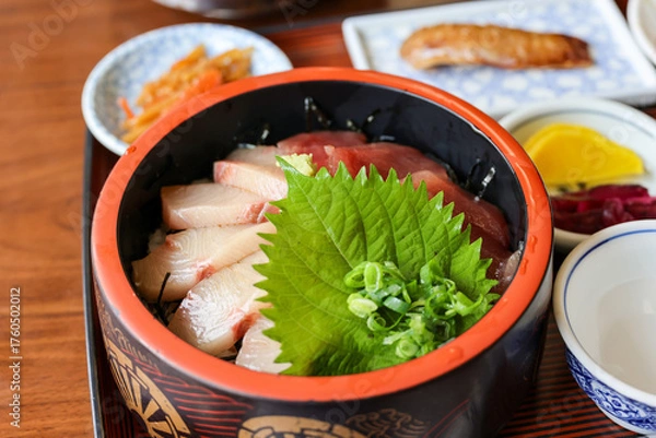 Fototapeta 黒い漆塗りの器に大葉と刻みネギが盛り付けられた海鮮丼