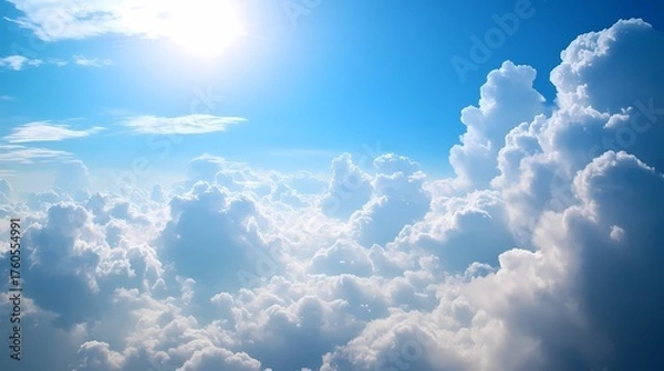 Obraz Expansive view of fluffy clouds illuminated by sunlight against a clear blue sky, evoking tranquility