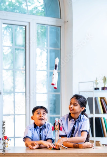 Fototapeta Indian students explore space rocket model in classroom while learning aerospace concepts in uniform