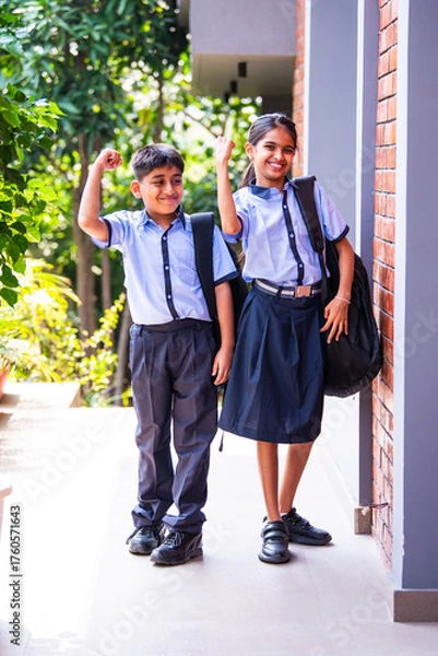 Obraz Indian Cheerful school kids in uniform smile at camera while standing outdoors on a sunny school day