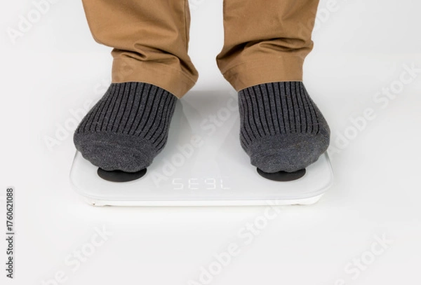 Obraz Senior man on scales indoors, close up. Weight gain.