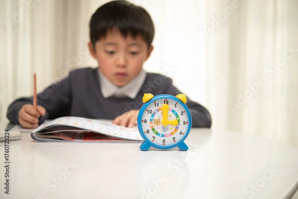 Fototapeta 時計と勉強する子供