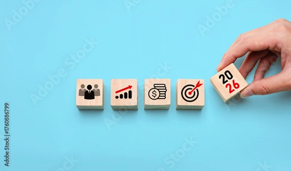 Fototapeta 2026 business strategy planning concept with hand placing wooden blocks showing icons of team, growth, finance, and target, symbolizing future goals, leadership, development, and success planning