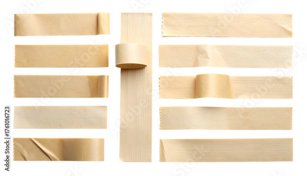 Fototapeta Various tan paper tape pieces and a roll arranged on a dark background