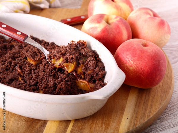 Fototapeta Homemade Chocolate peach crumble dessert in a tin