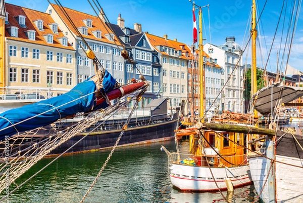 Fototapeta Copenhagen iconic view. Famous old Nyhavn port in the center of Copenhagen, Denmark during summer sunny day with a boat on the foreground.