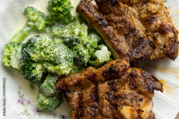 Fototapeta Cooked, steamed broccoli in a cream sauce and grilled pork ribs.