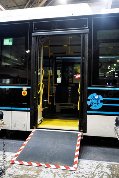 Obraz Modern public bus with an open door and deployed accessibility ramp, highlighting inclusive urban transport. Perfect for mobility and city travel concepts.