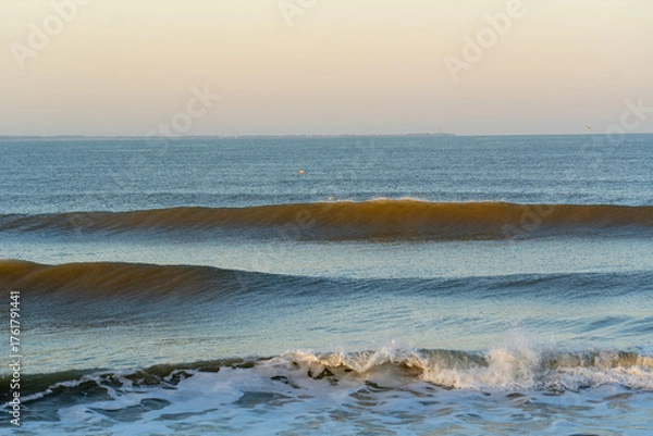 Obraz Tranquil ocean scene featuring evenly breaking waves under the gentle glow of early morning light. 