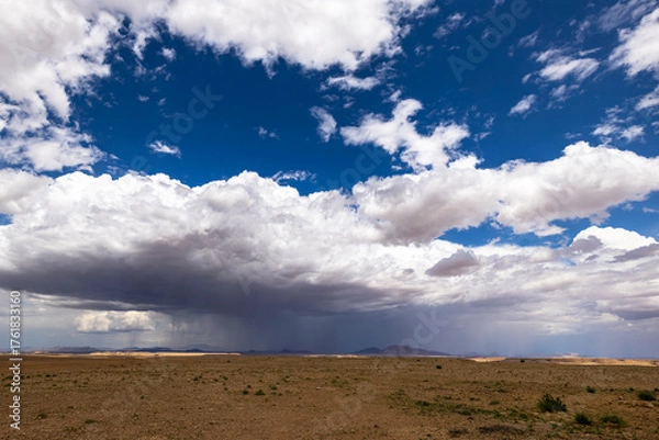 Obraz Rain from white cumulus clouds in the desert