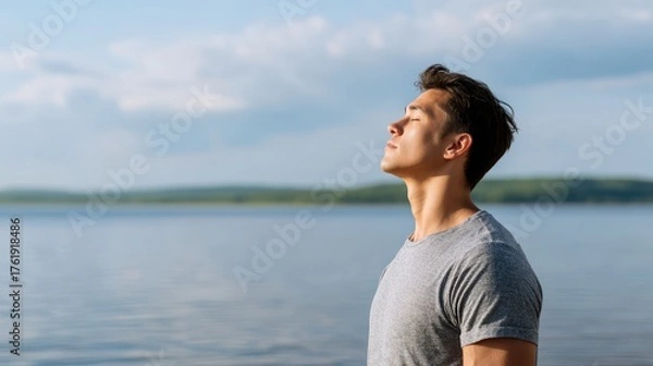 Fototapeta Man Practicing Deep Breathing by Lake with Nature Backdrop