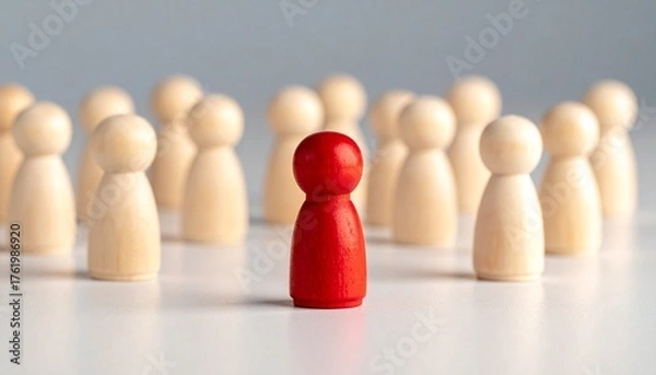 Fototapeta Red figurine stands out in center of wooden circle, symbolizing uniqueness and leadership.