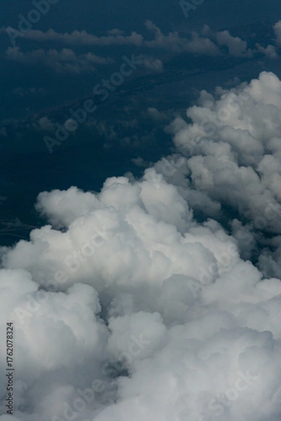 Fototapeta View of White Clouds from Airplane Window. Beautiful aerial view of soft white clouds from an airplane window during flight. The peaceful atmosphere of the sky above the clouds.