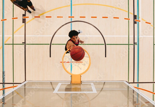 Obraz Top view of a basketball player making a shot on an indoor court