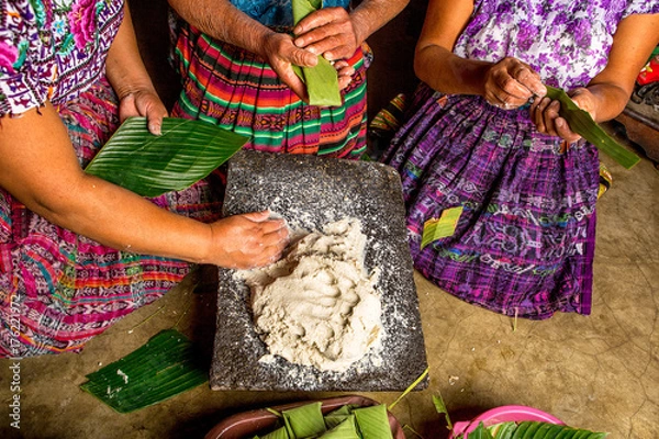 Fototapeta San Pedro la Laguna, Guatemala: Mayan women in traditional wear preparing food together