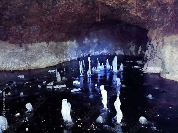 Fototapeta A cave with a stream of water and ice in it