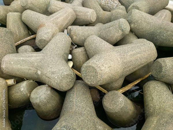 Fototapeta テトラポットとも呼ばれる消波ブロックが設置されている海沿いの防波堤のイメージ