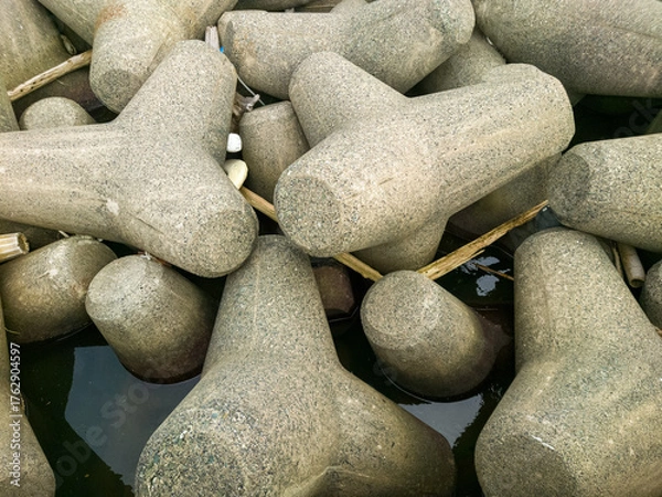 Fototapeta テトラポットとも呼ばれる消波ブロックが設置されている海沿いの防波堤のイメージ