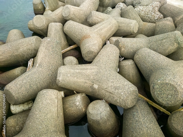 Fototapeta テトラポットとも呼ばれる消波ブロックが設置されている海沿いの防波堤のイメージ