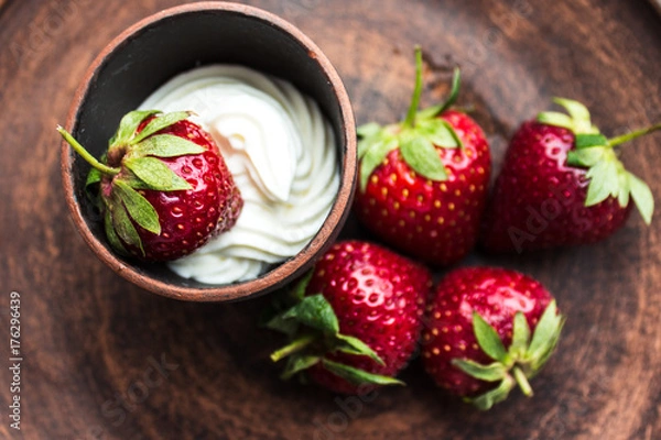 Fototapeta fresh strawberry with whipping cream on a dark plate