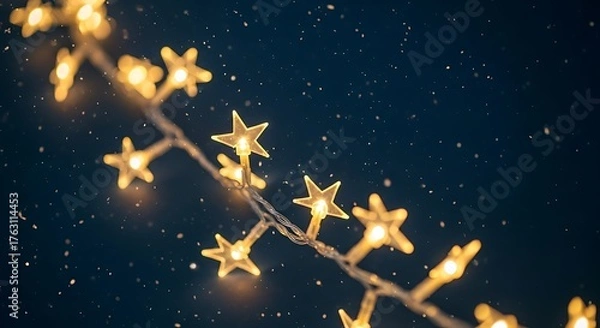 Fototapeta A string of warm golden star shaped lights glows against a dark starry night sky creating a magical and festive atmosphere perfect for holidays and celebrations