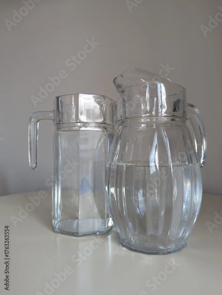 Fototapeta A decorative pair of transparent glass pitchers with unique designs, perfect for home styling concepts.