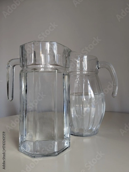 Fototapeta Two jugs ready with fresh water, promoting hydration and healthy choices. A clean, lifestyle-focused image.
