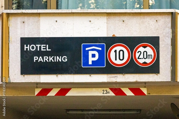 Fototapeta Garage entrance public parking sign on urban street in city