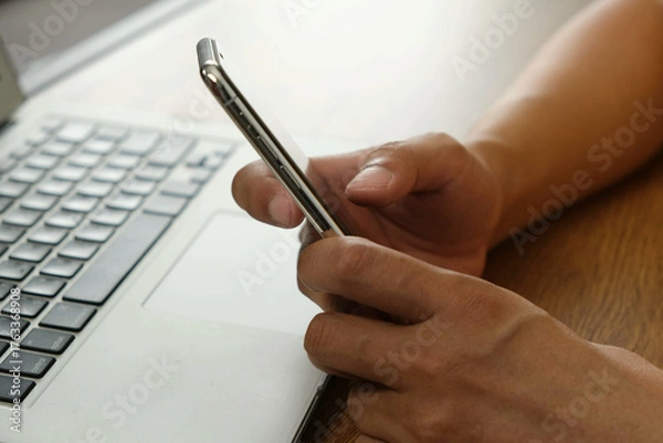 Fototapeta Person using smartphone near laptop, mobile transaction technology concept