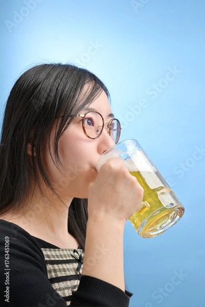 Fototapeta ジョッキでビールを飲む若い日本人女性