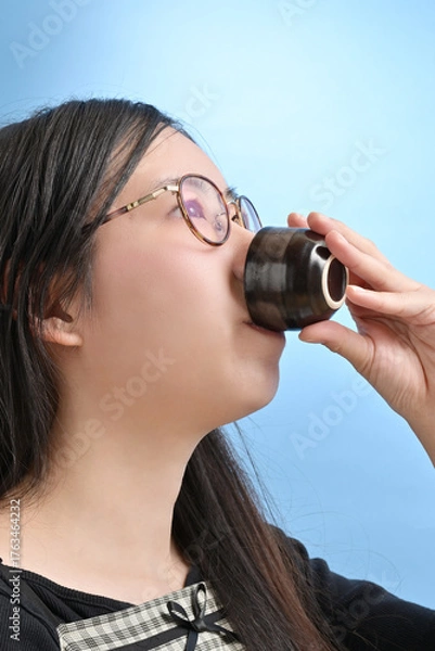 Obraz 猪口で日本酒を飲む若い日本人女性