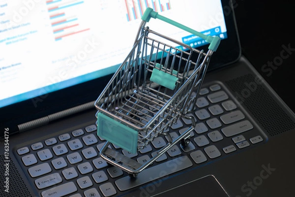 Fototapeta Miniature Shopping Cart on Laptop Displaying E Commerce Business Data