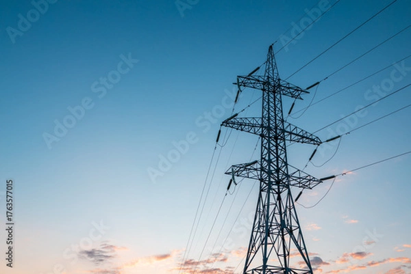 Fototapeta silhouette of a single pole of high-voltage electricity transmission lines against the blue sky at dawn