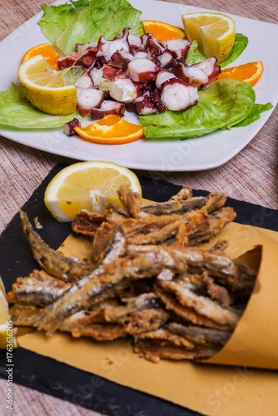 Obraz Cuoppo di alici fritte, polpo all'insalata e piatto con verdure fritte, bruschetta al pomodoro e fritto misto napoletano serviti come antipasti in una trattoria