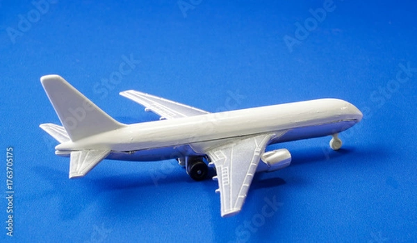 Fototapeta Model airplane on a blue background showcasing intricate details of aviation design