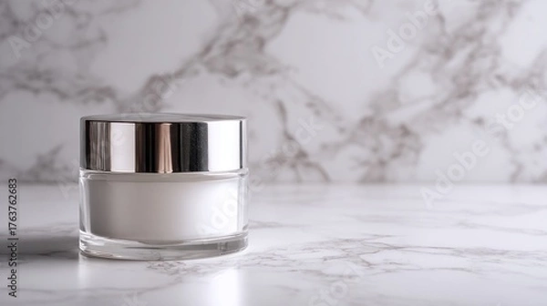 Obraz Clear cosmetic jar containing white cream rests on a polished marble surface with a matching backdrop.