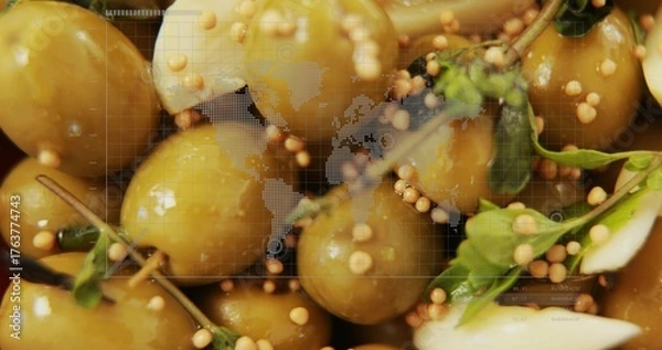 Fototapeta Glossy green olives tumbling closeup with mustard seeds and herbs under world map grid overlay