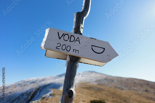 Fototapeta Sign, placard, guidepost with Czech and Slovak text Voda, translation Water.  Well and spring - arrow showing direction to natural source of drinking and potable water in the nature. Shallow focus.