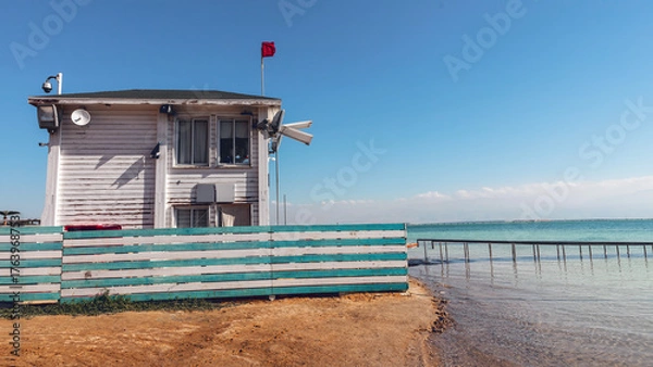 Fototapeta A wooden lifeguard station on the shore of a warm sea