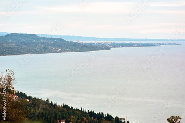 Obraz A breathtaking aerial view of a coastline bathed in pre-sunset light, where the golden hour transforms the landscape into a masterpiece of warm tones.