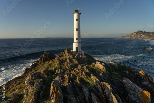 Fototapeta Cabo (cape) Home lighthouse on the cliffs at sunset in Rias Baixas zone in Galicia coast.