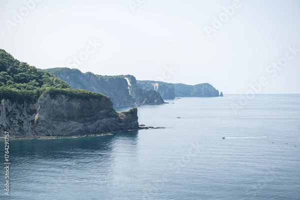 Fototapeta Coastal cliffs overlooking calm sea under clear sky during daytime Cape Ogon, Shakotan, Hokkaido, Japan