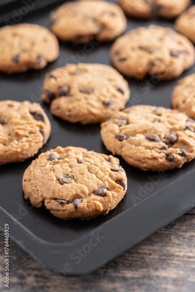 Obraz Baked chocolate chip cookies on a black baking tray