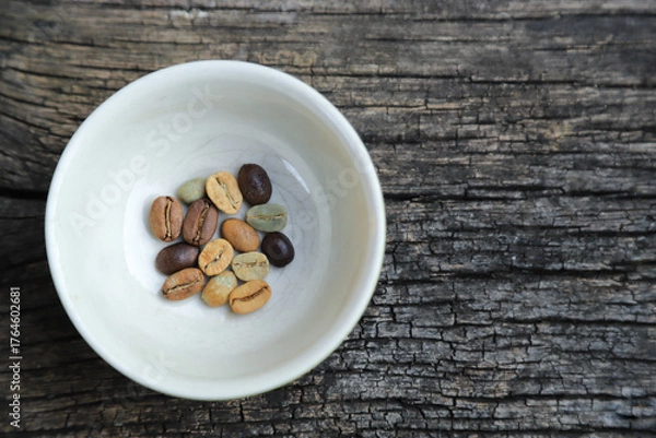 Obraz Color roast level of green coffee bean to dark roasted bean on wooden board. top view.