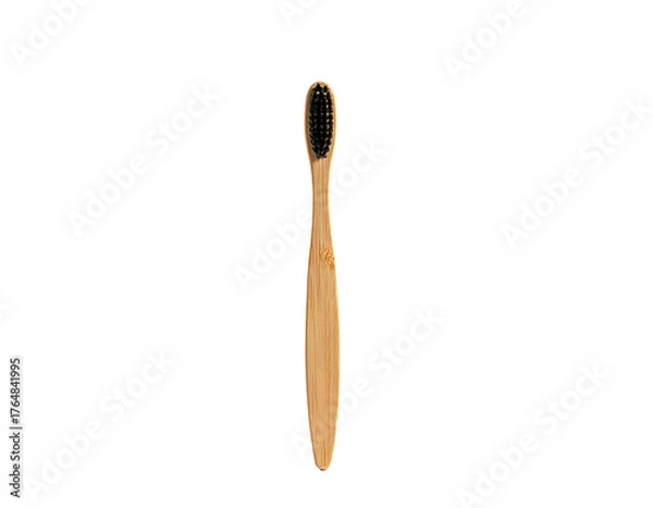 Obraz A wooden toothbrush with black bristles, displayed vertically against a dark, isolating background