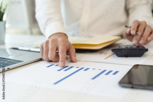 Fototapeta Deduction planning, debt asian accountant hand using calculator to calculating money balance from bill and income, cost budget expenses for pay money form personal individual on table at home.