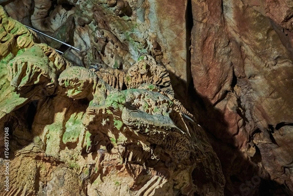 Fototapeta Vadu Crisului Cave in Bihor, Romania, features impressive limestone formations. Stalactites hang from the ceiling, while stalagmites rise from the floor, some meeting to form columns