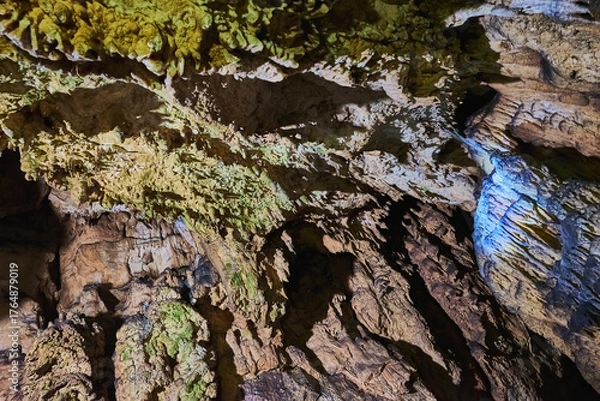 Fototapeta Vadu Crisului Cave in Bihor, Romania, features impressive limestone formations. Stalactites hang from the ceiling, while stalagmites rise from the floor, some meeting to form columns