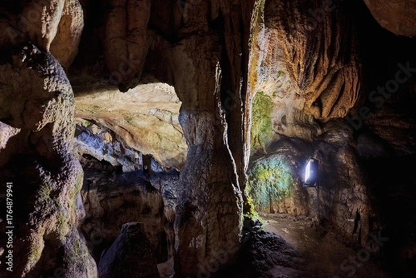 Fototapeta Vadu Crisului Cave in Bihor, Romania, features impressive limestone formations. Stalactites hang from the ceiling, while stalagmites rise from the floor, some meeting to form columns