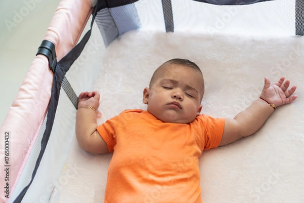 Fototapeta Baby sleeping peacefully in crib concept of rest